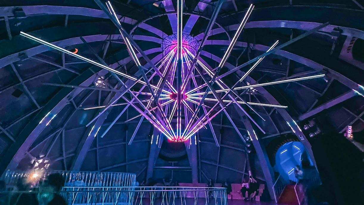 Illuminated interior structure of the Atomium in Brussels with colorful lights.
