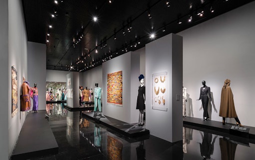 Fashion exhibit at YSL Museum in Marrakech showcasing designer clothing and accessories.