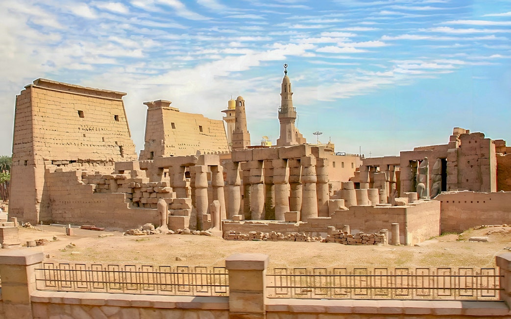 Luxor Temple ruins with ancient columns and pylons under a blue sky in Egypt.