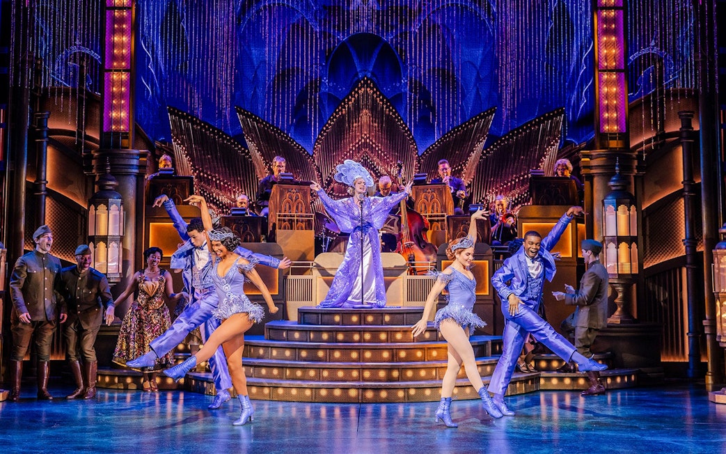 Stage performance of The Great Gatsby in New York with dancers in vibrant costumes.