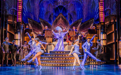 Stage performance of The Great Gatsby in New York with dancers in vibrant costumes.