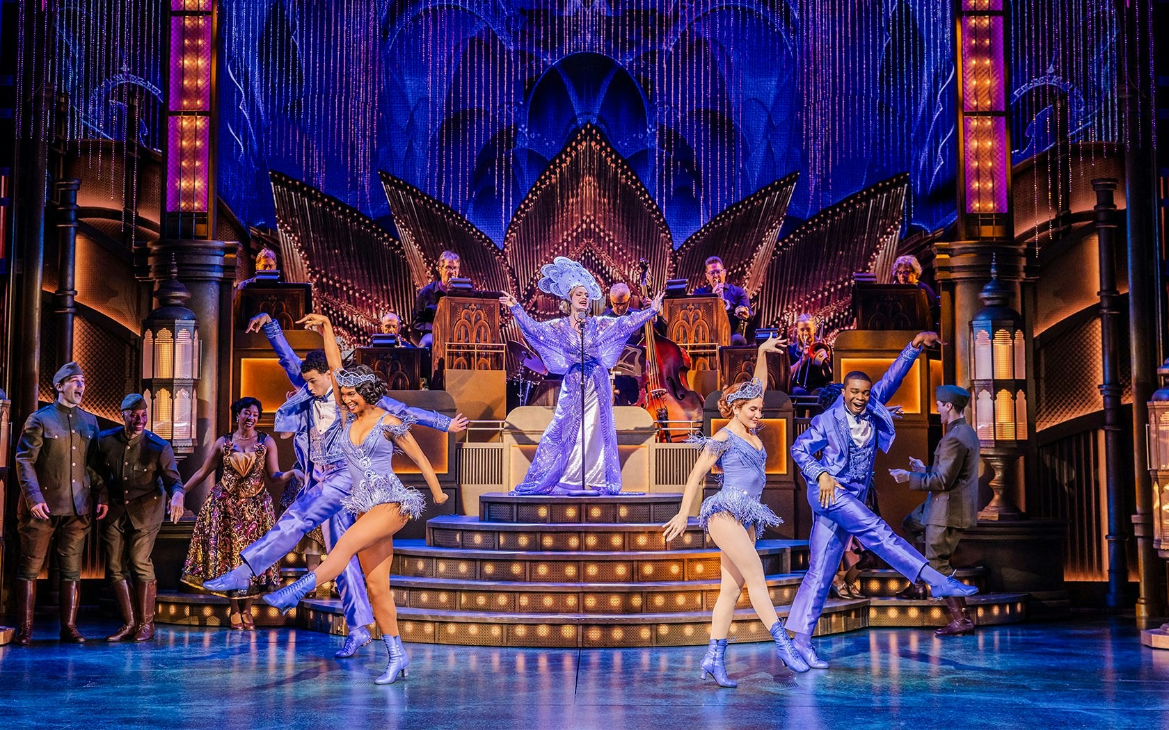 Stage performance of The Great Gatsby in New York with dancers in vibrant costumes.