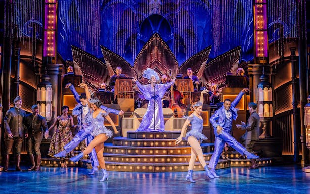 Stage performance of The Great Gatsby in New York with dancers in vibrant costumes.