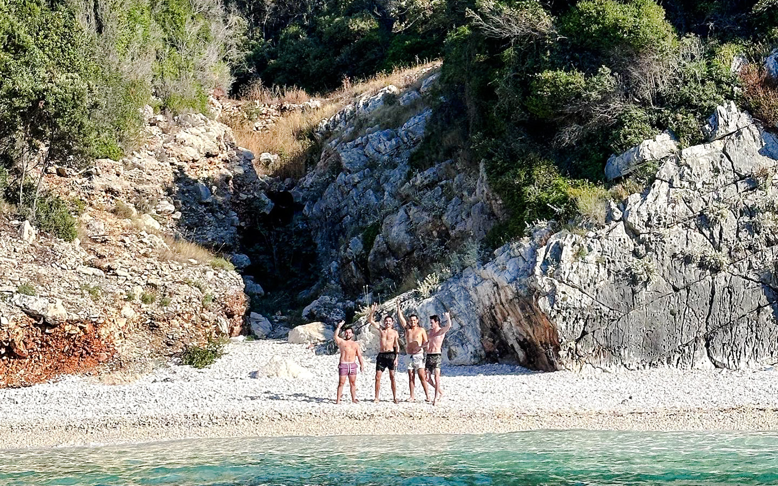 Tourists on a rocky beach at Sazan Island, Albania, near Haxhi Ali Cave.