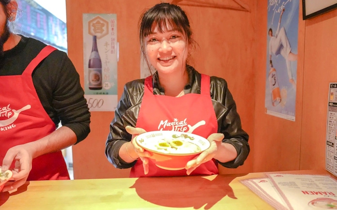Kyoto cooking class participant holding a bowl of ramen.
