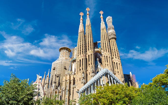Sagrada Familia's intricate spires against a clear blue sky in Barcelona.