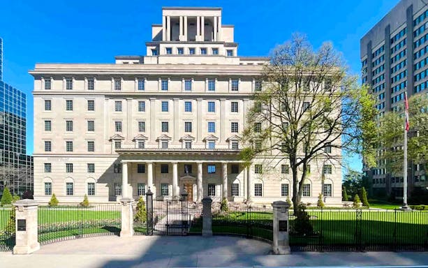 Historic Manulife Financial Corporation building with columns and manicured lawn in Toronto.