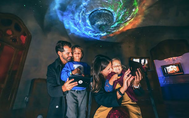 Family exploring Casa Batlló interior with digital guide, Barcelona.