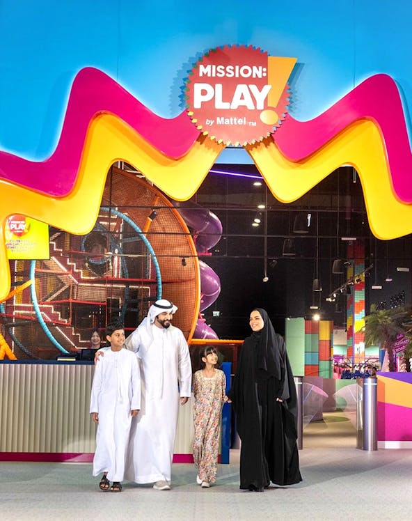 Family enjoying Mission: Play! by Mattel indoor play area with colorful structures.