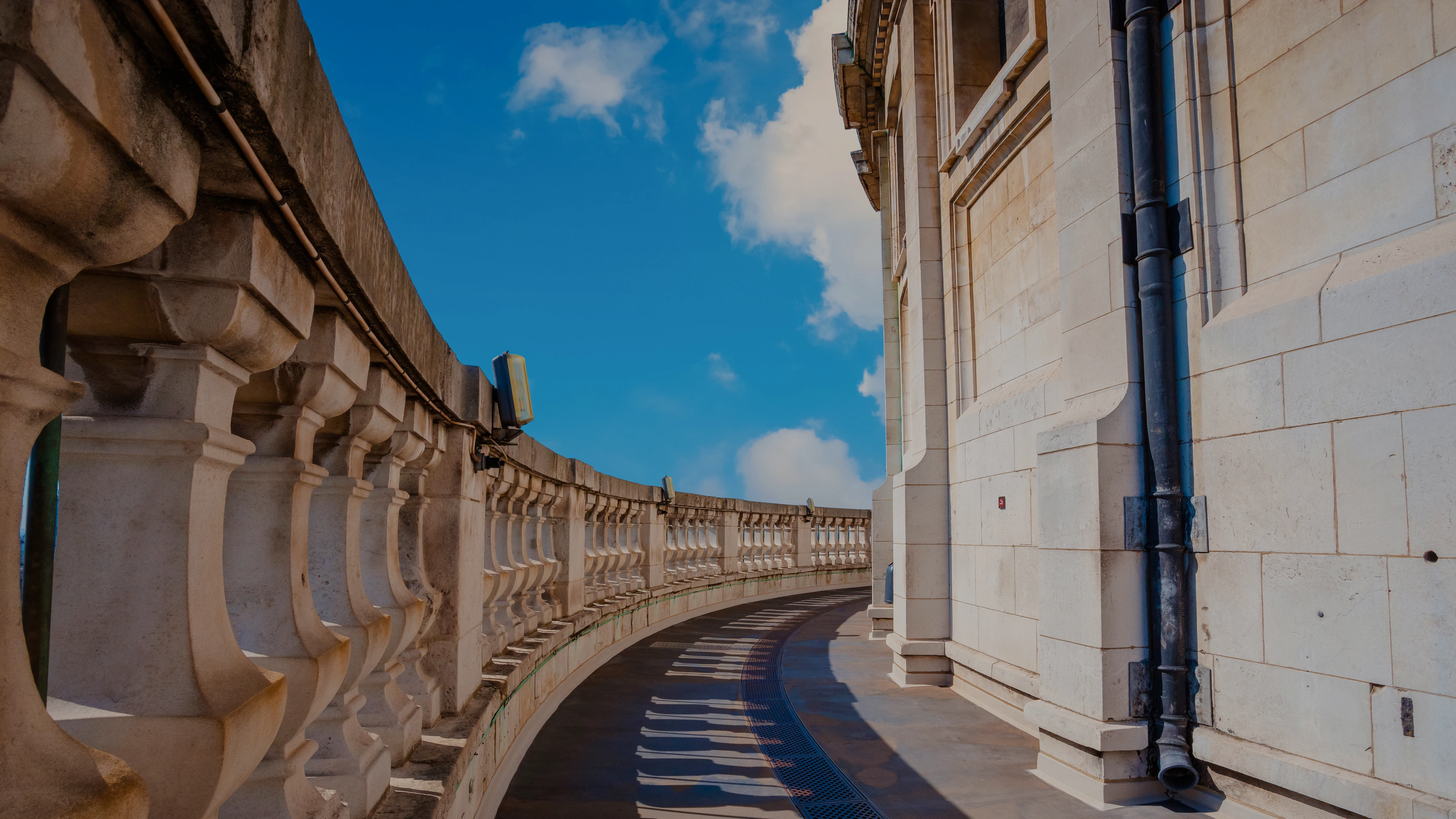 Stone gallery walkway at St Paul's Cathedral, London, with blue sky background.