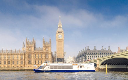 Cruise boat on the Thames near Westminster and Houses of Parliament, London.