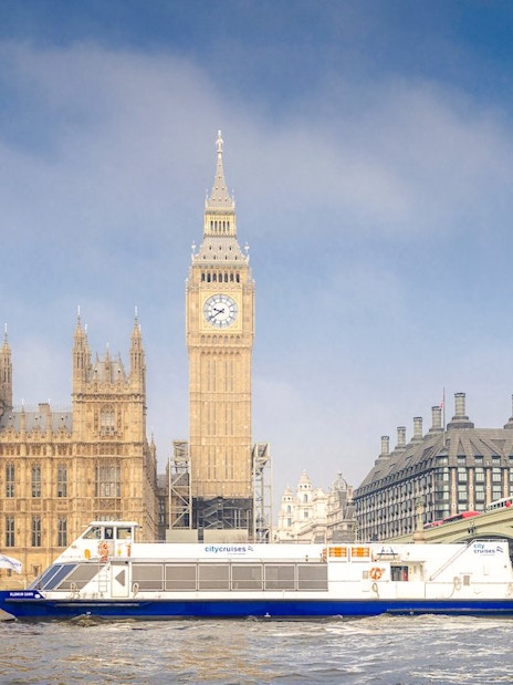 Cruise boat on the Thames near Westminster and Houses of Parliament, London.