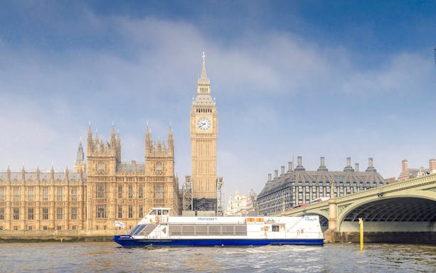 Cruise boat on the Thames near Westminster and Houses of Parliament, London.