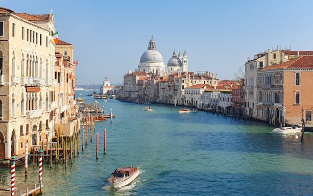 Grand Canal view from Rialto to Punta della Dogana, Venice, with boats and historic buildings.