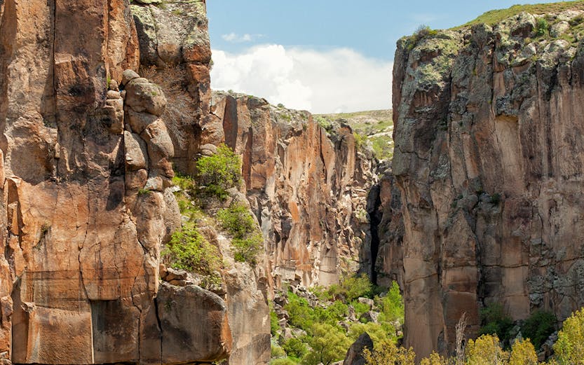 Ihlara Valley canyon with steep rock walls and lush greenery, Cappadocia, Turkey.