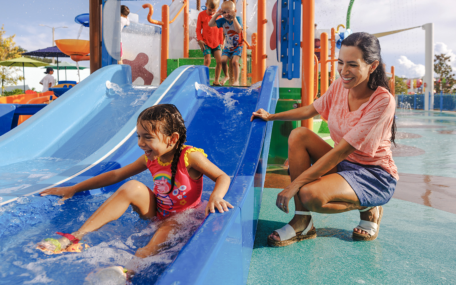 Child enjoying water slide at Peppa Pig Theme Park, Florida.