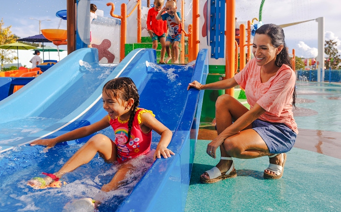 Child enjoying water slide at Peppa Pig Theme Park, Florida.