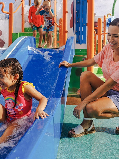 Child enjoying water slide at Peppa Pig Theme Park, Florida.