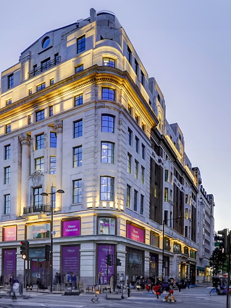 Moco Museum London entrance on a busy street corner at dusk.