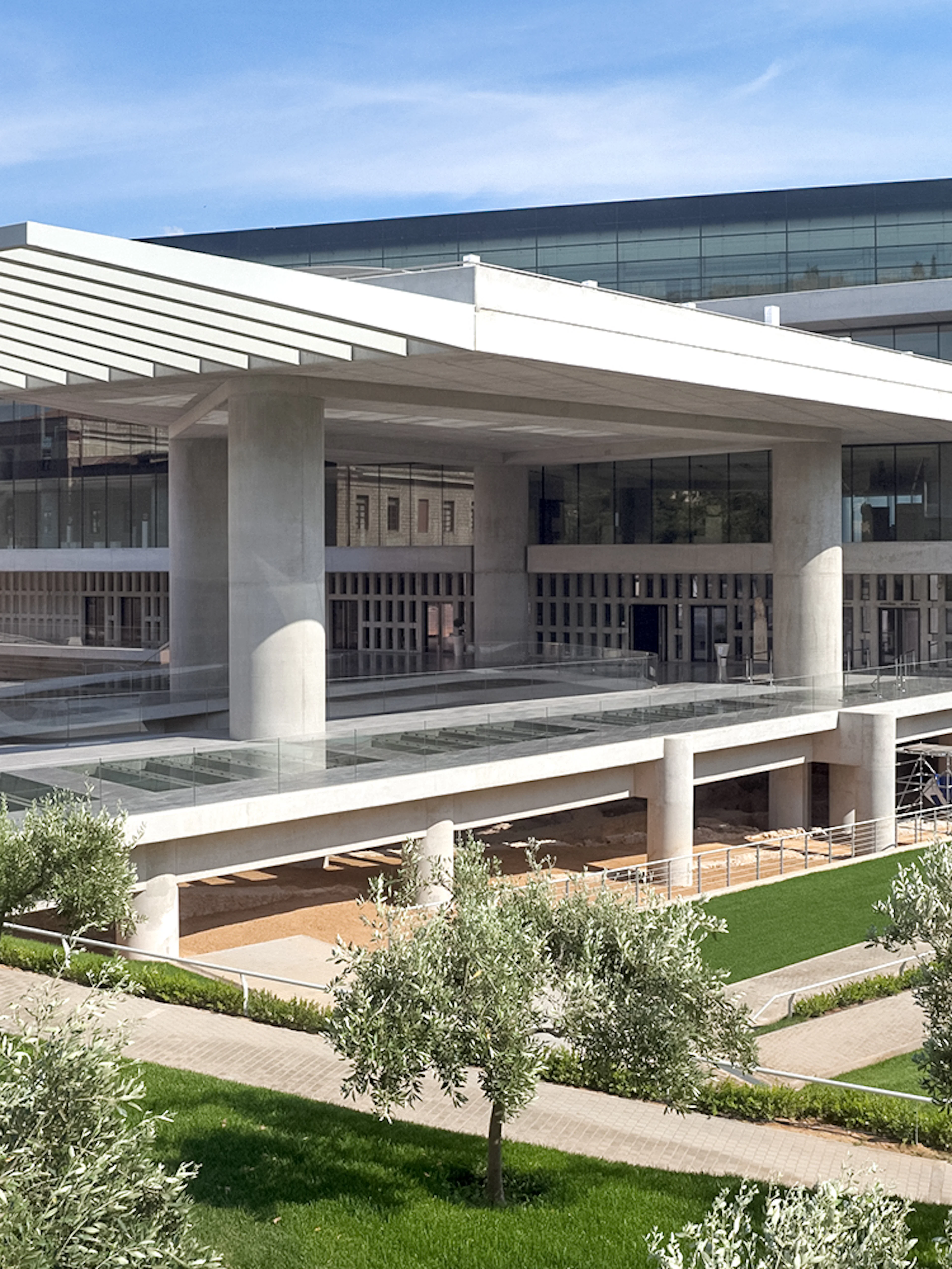 Acropolis Museum exterior with modern architecture and surrounding greenery in Athens, Greece.