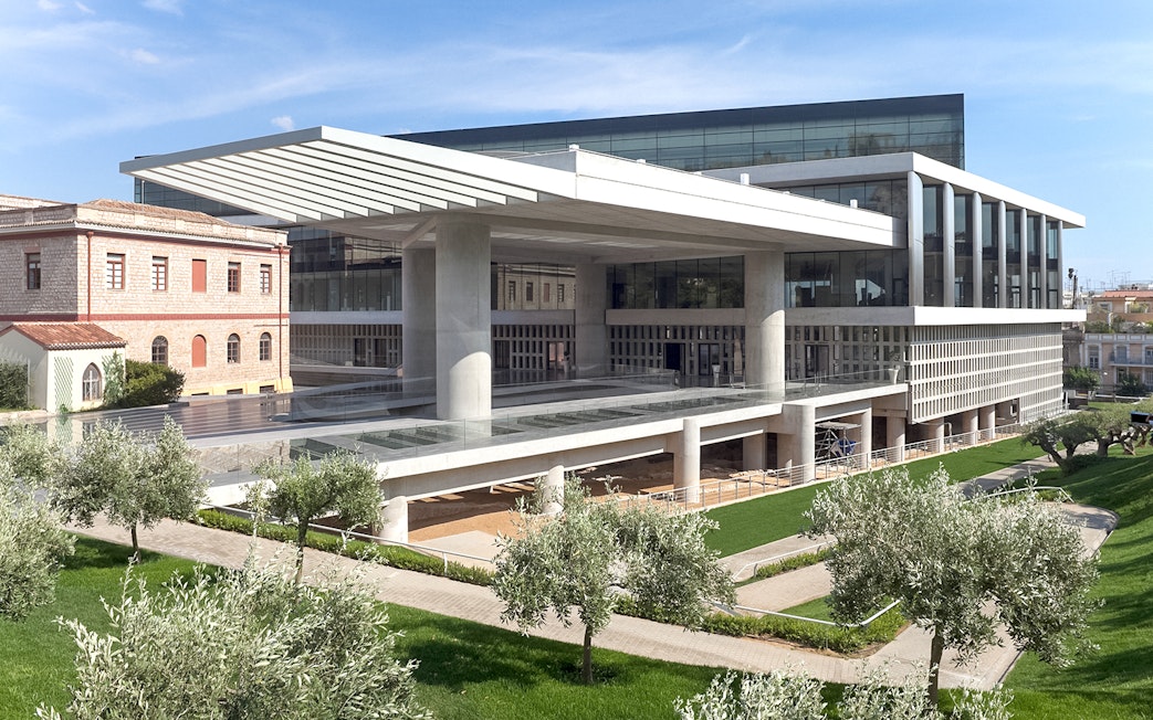 Acropolis Museum exterior with modern architecture and surrounding greenery in Athens, Greece.