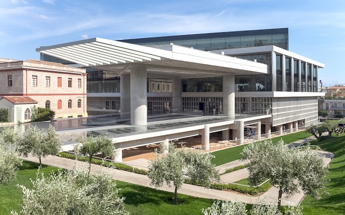 Acropolis Museum exterior with modern architecture and surrounding greenery in Athens, Greece.