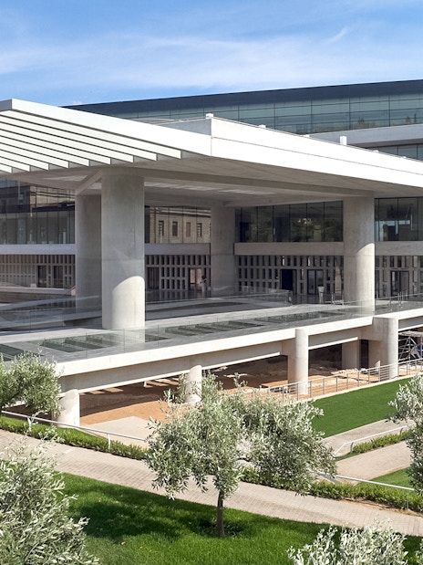 Acropolis Museum exterior with modern architecture and surrounding greenery in Athens, Greece.