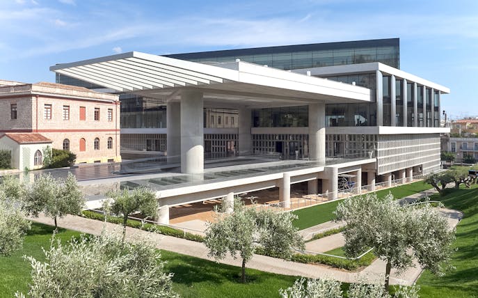 Acropolis Museum exterior with modern architecture and surrounding greenery in Athens, Greece.