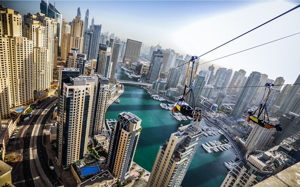 Ziplining over Dubai Marina with skyscrapers and waterfront views.