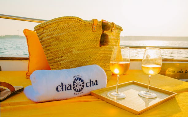 Wicker bag and wine glasses on a boat during New Dubai Skyscrapers Tour.
