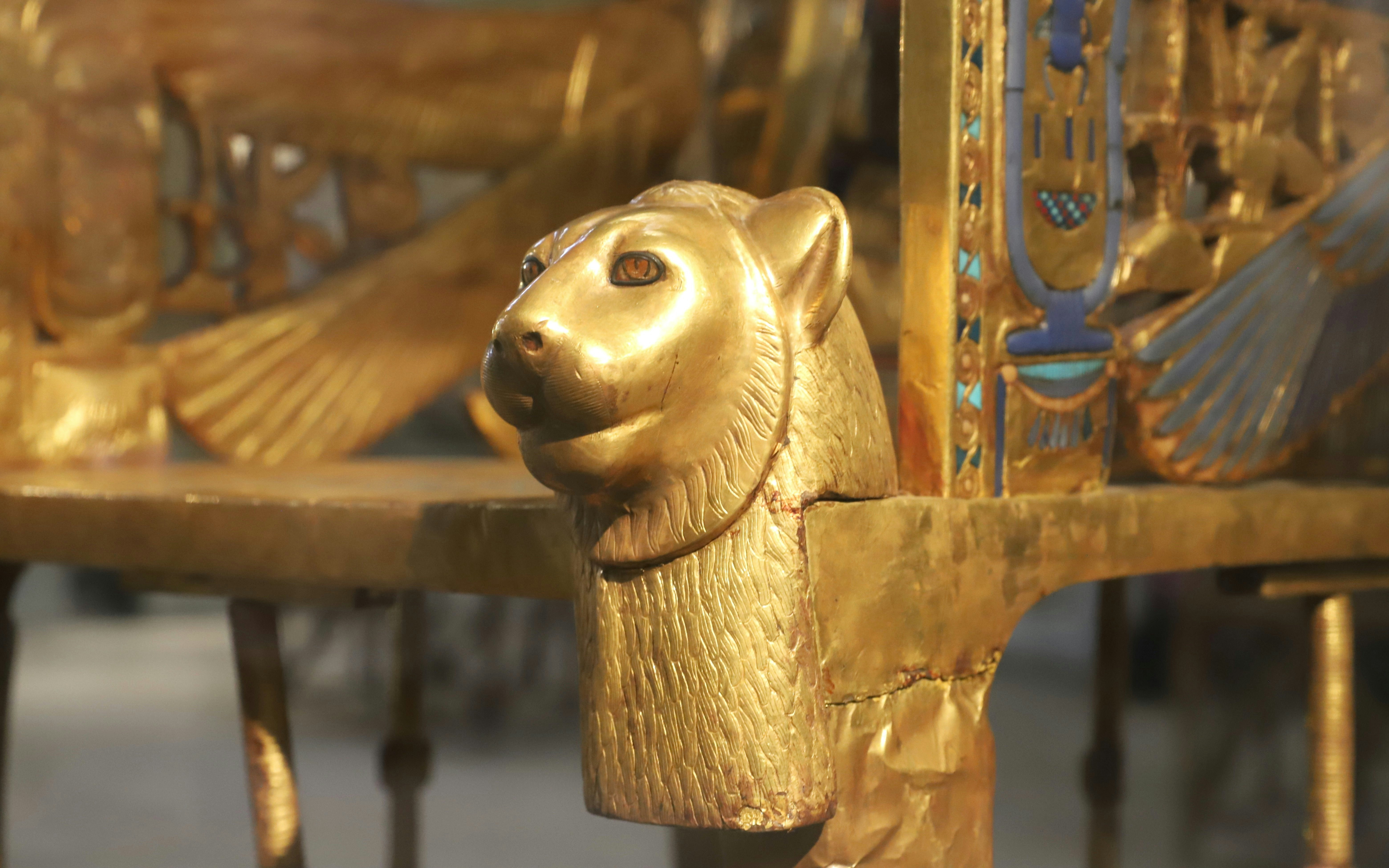 Golden lion head detail on Tutankhamun's throne at the Grand Egyptian Museum.
