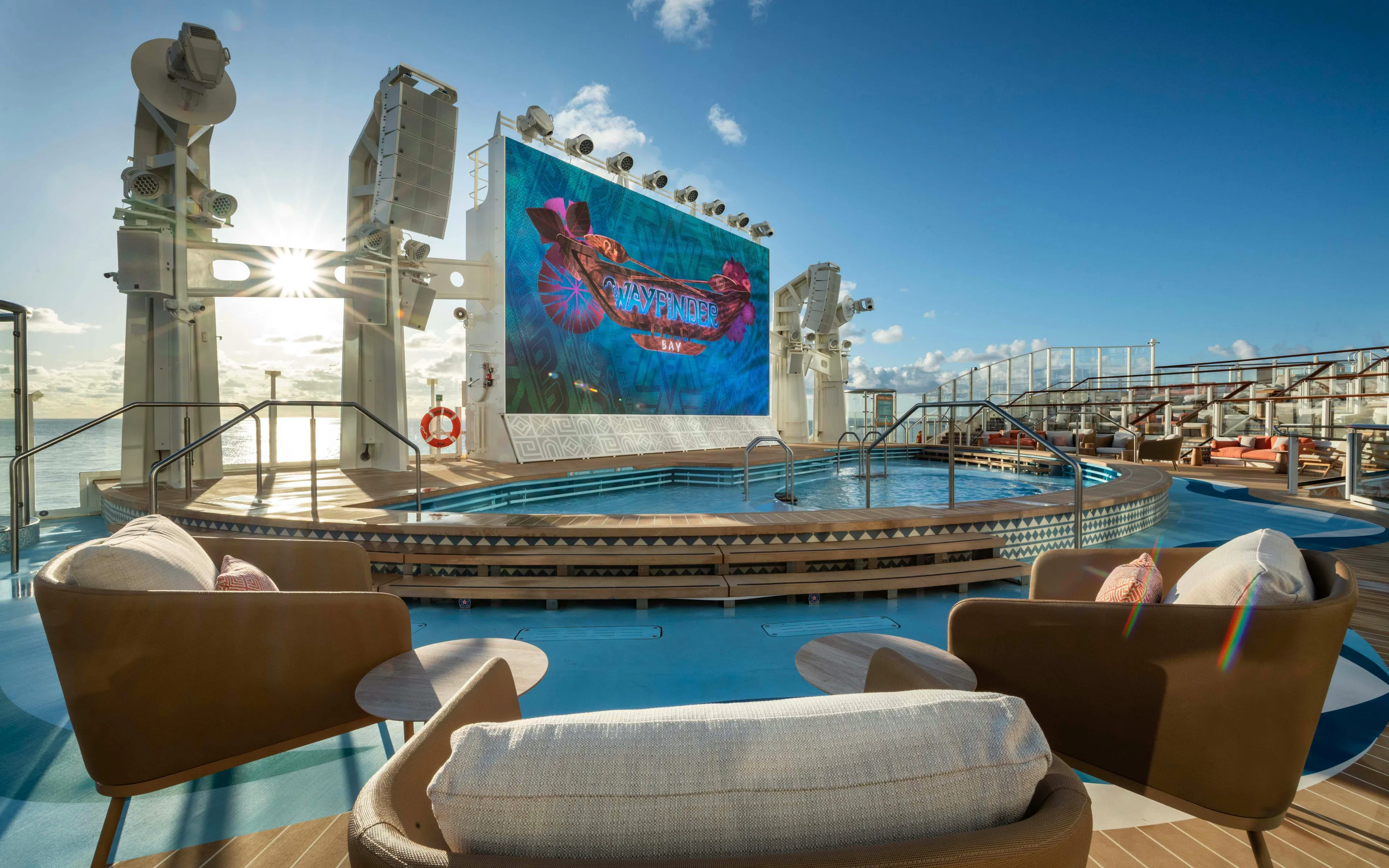 Outdoor pool deck with large screen displaying "Wayfinder Bay" on Disney Cruise Line.