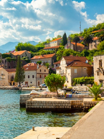 Coastal village with stone houses and red roofs along the Dubrovnik to Montenegro route.