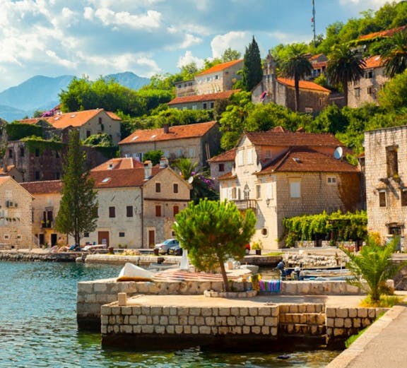 Coastal village with stone houses and red roofs along the Dubrovnik to Montenegro route.