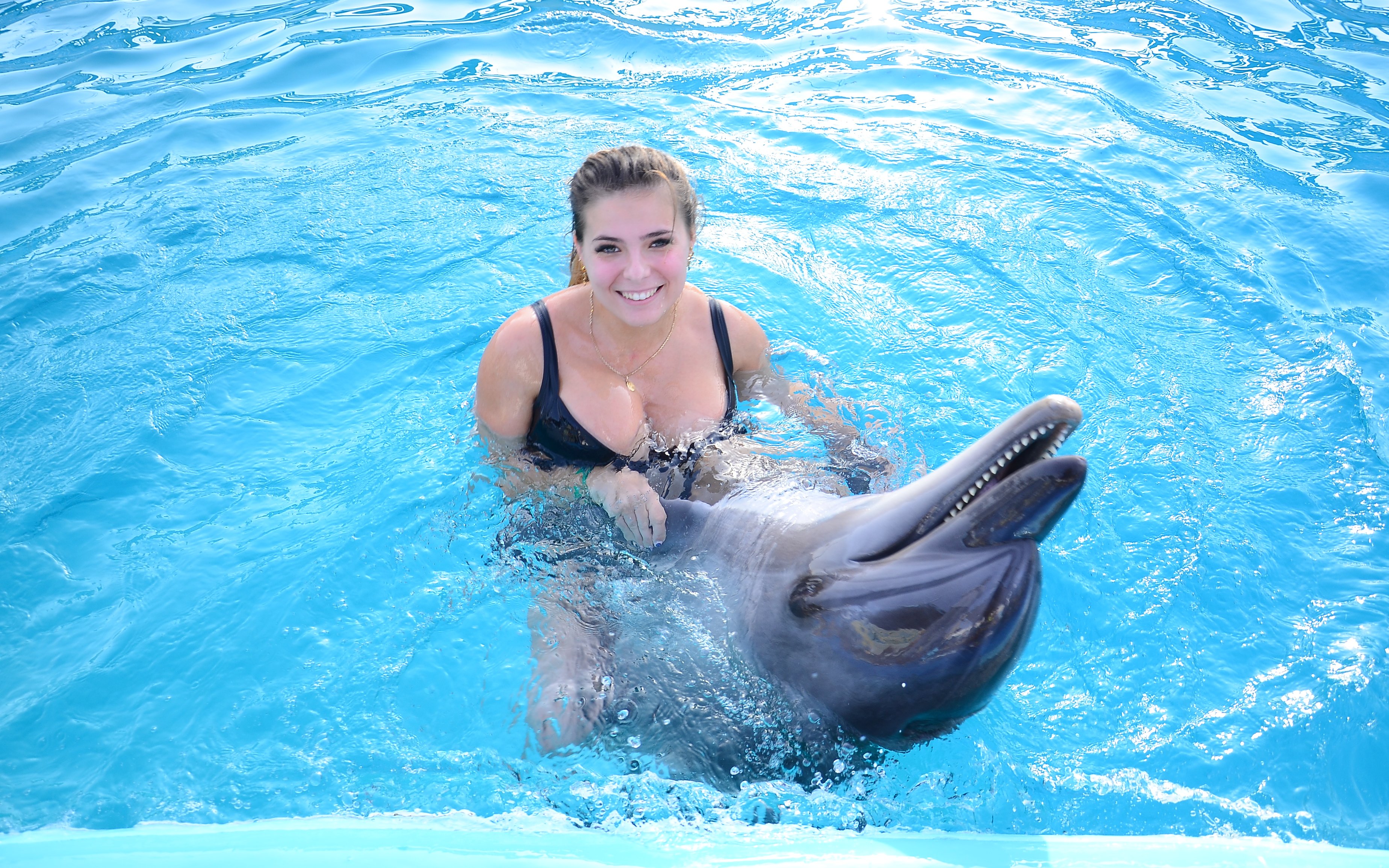 Woman swimming with dolphin at Dolphin World Egypt, Hurghada.