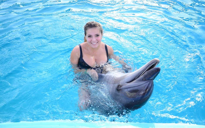 Woman swimming with dolphin at Dolphin World Egypt, Hurghada.