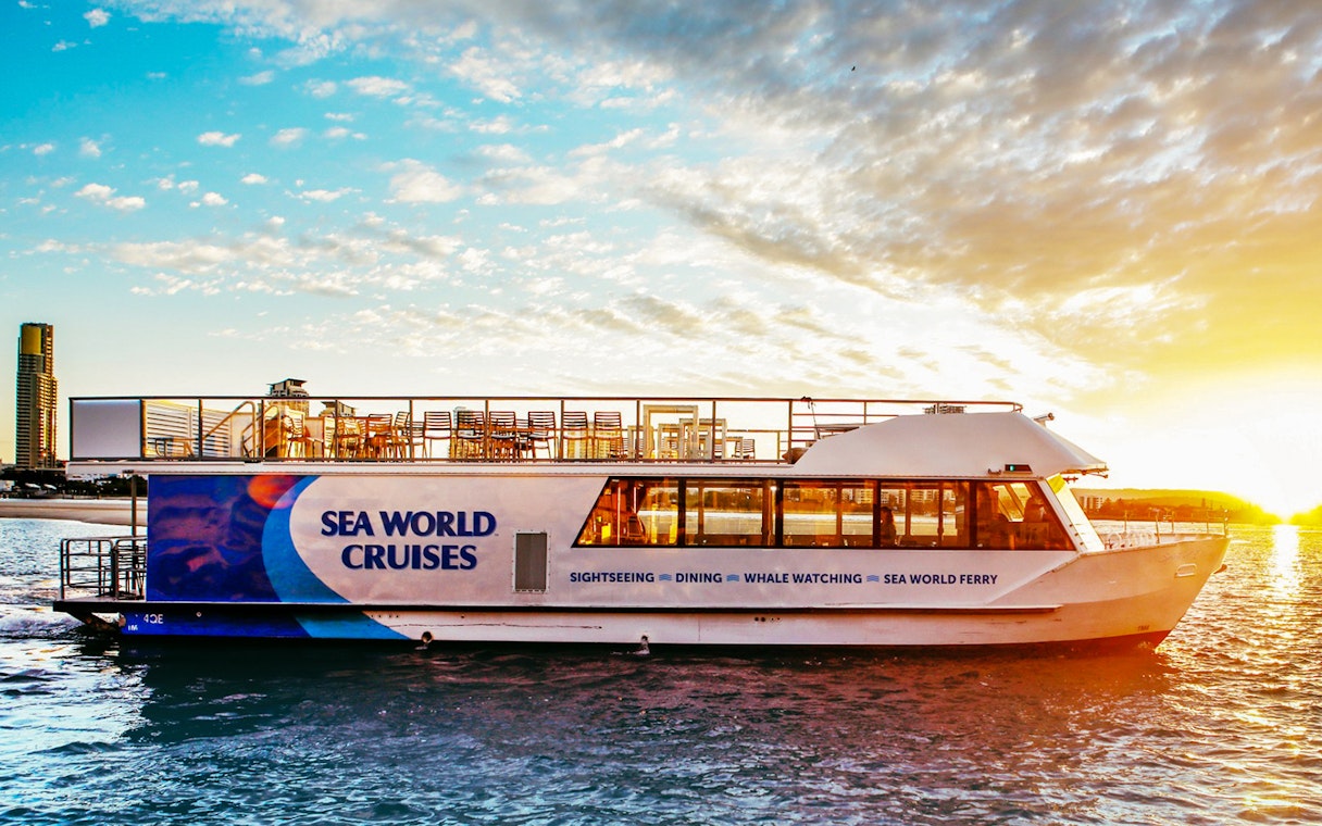 Cruise ship on water at sunset, offering buffet dinner experience.