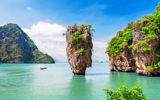 Canoeing near limestone cliffs at James Bond Island, Phang Nga Bay, Thailand.