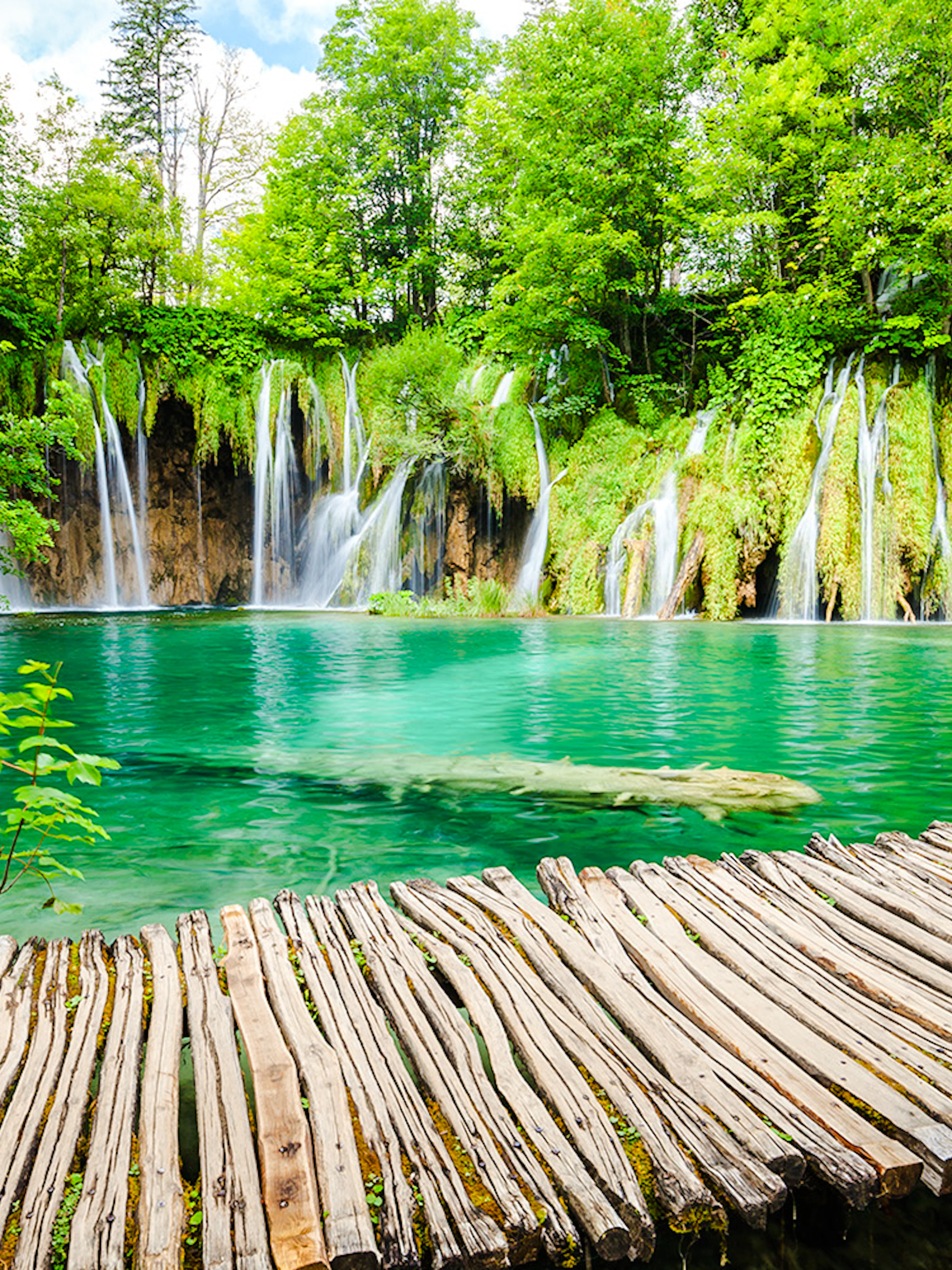 Wooden path over turquoise water and waterfalls at Plitvice Lakes National Park, Croatia.