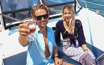 Couple enjoying drinks on a Harbour Highlights Catamaran Cruise.