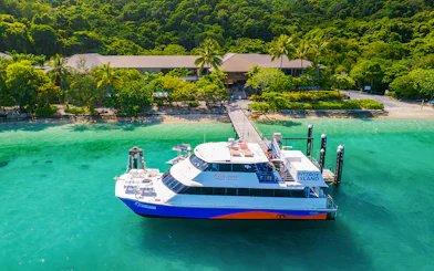 Fitzroy Island ferry docked at lush green island, Cairns day trip.