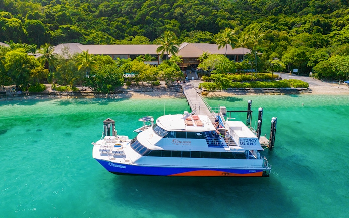 Fitzroy Island ferry docked at lush green island, Cairns day trip.