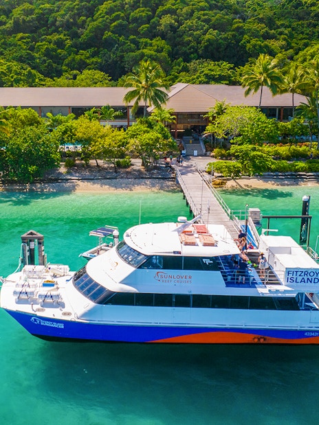 Fitzroy Island ferry docked at lush green island, Cairns day trip.