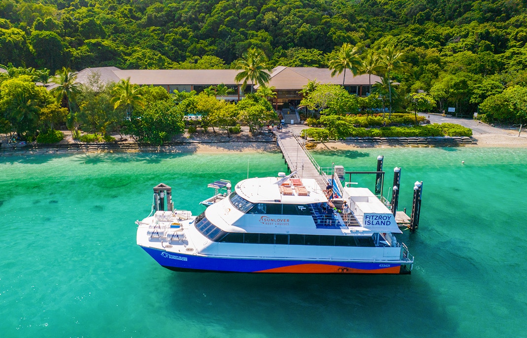 Fitzroy Island ferry docked at lush green island, Cairns day trip.