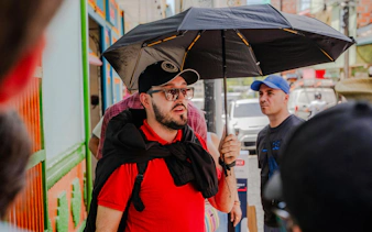 Guide leading guests on Guatapé & El Peñol Full-Day Tour with umbrella.