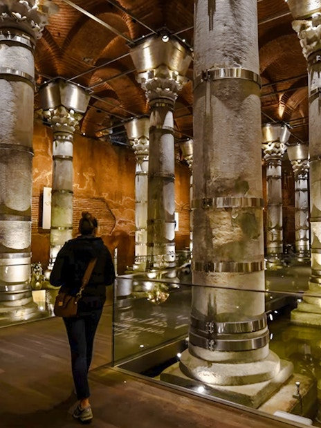 Visitors exploring Theodosius Cistern with illuminated columns in Istanbul.