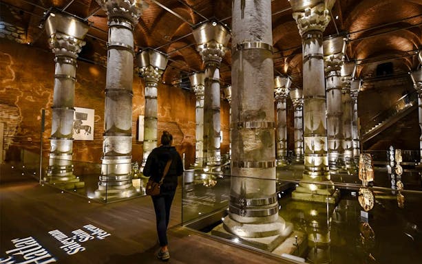 Visitors exploring Theodosius Cistern with illuminated columns in Istanbul.