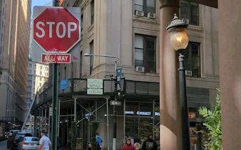 Stop sign at Beaver Street intersection in Downtown New York, part of Ghost of Wall Street exploration game.