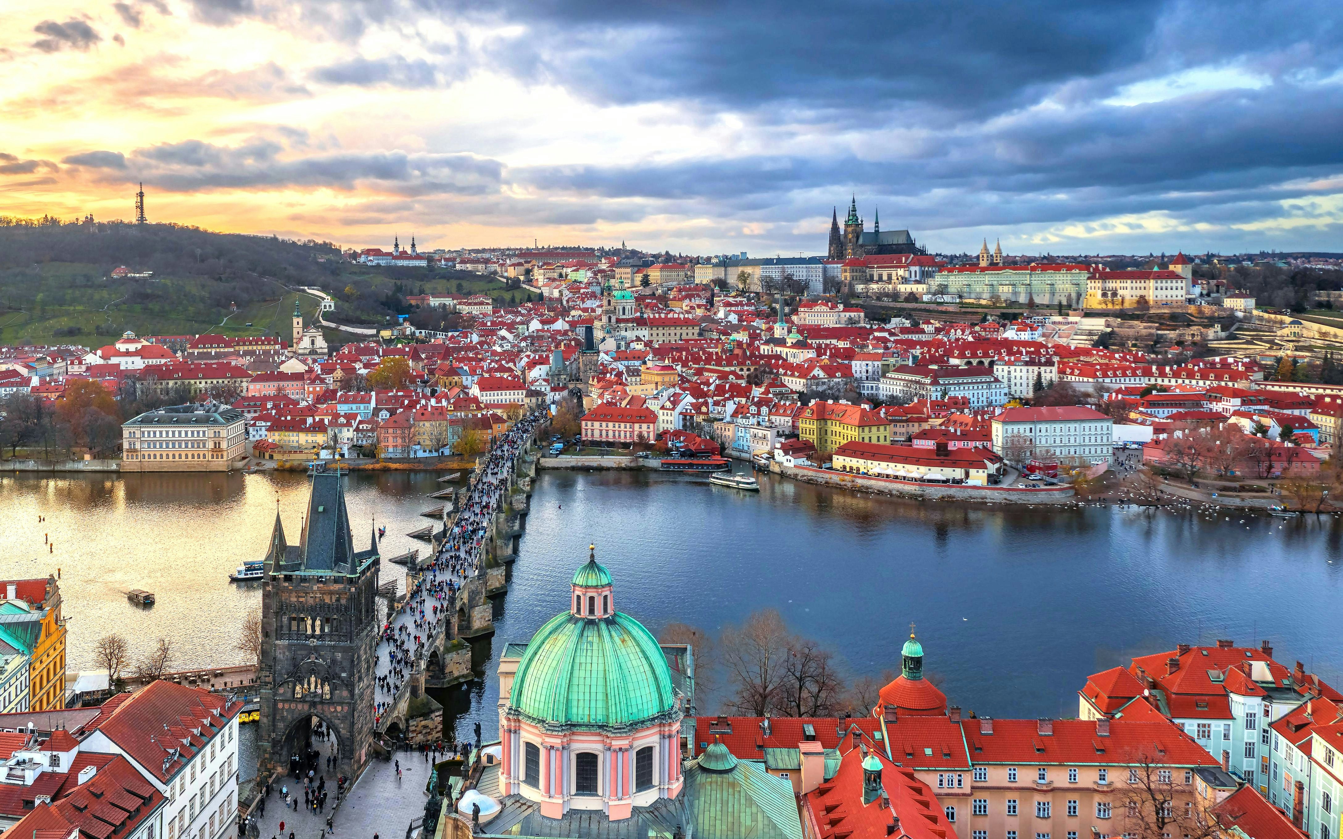 Aerial view of Charles Bridge spanning the Vltava River in Prague, Czech Republic, with historic buildings.