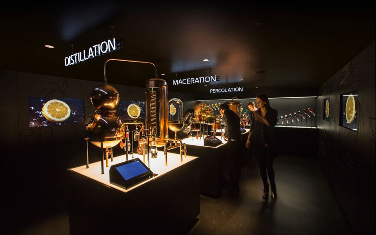 Visitors exploring distillation exhibits at Amsterdam House of Bols cocktail workshop.